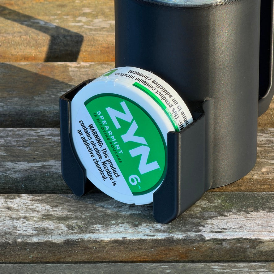 Close-up of the front pocket holding a green spearmint nicotine pouch can against the black holder body