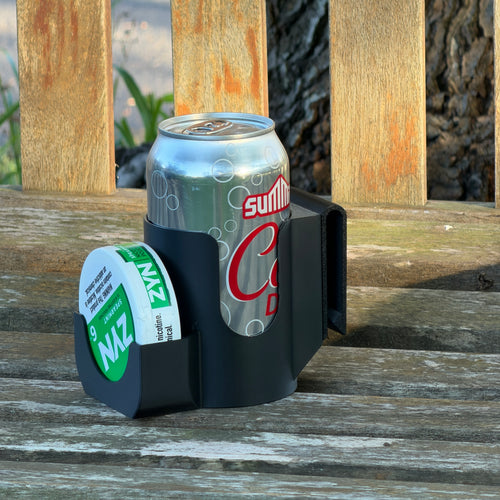 Black Can + Pouch Holster on a wooden bench, holding a silver soda can upright with a nicotine pouch can in the side pocket