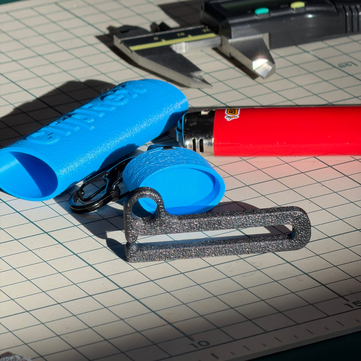 Blue ClipRex lighter holder shown next to a full-size lighter and its clip